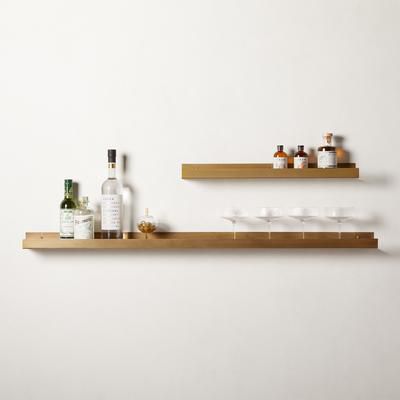 two gold floating shelves with cocktail glasses on them